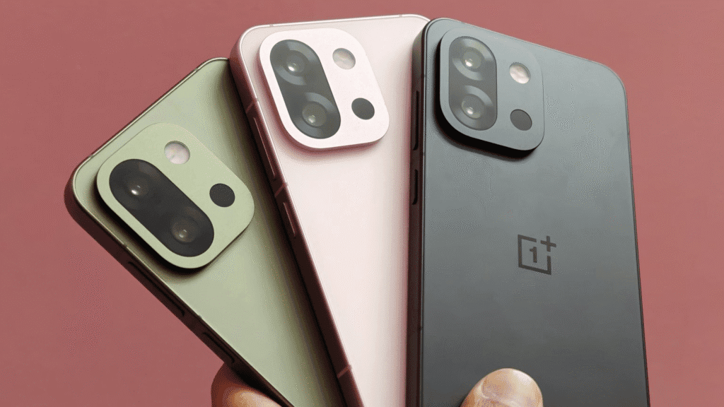 OnePlus 13s smartphones in black, pink, and green colors held in a hand against a pink background